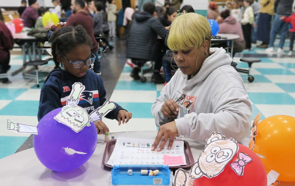Mom and child looking at a paper together in the Healey School cafeteria