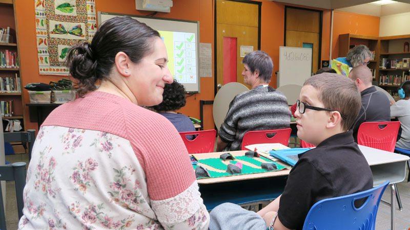 Educator and student talking in library